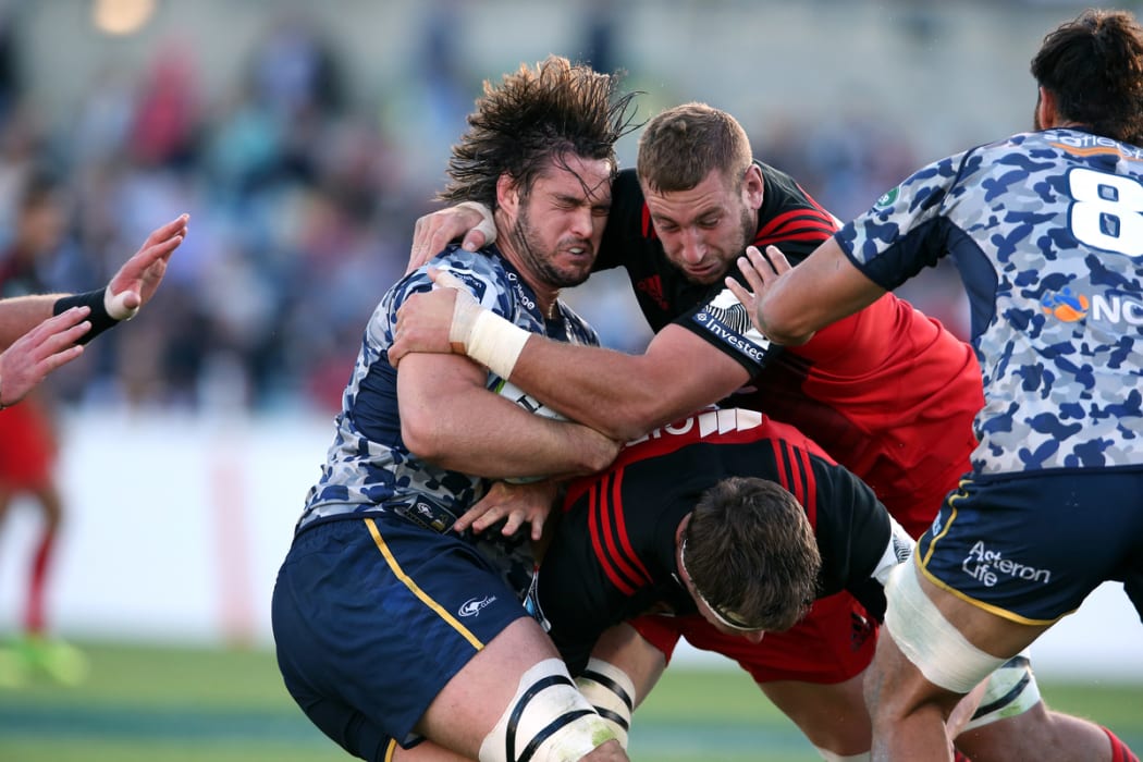 Sam Carter is tackled by Luke Ramano during the Super Rugby union match, Brumbies vs Crusaders in Canberra.