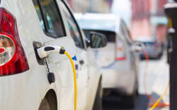Power supply for electric car charging.  Electric car charging station. Close up of the power supply plugged into an electric car being charged.