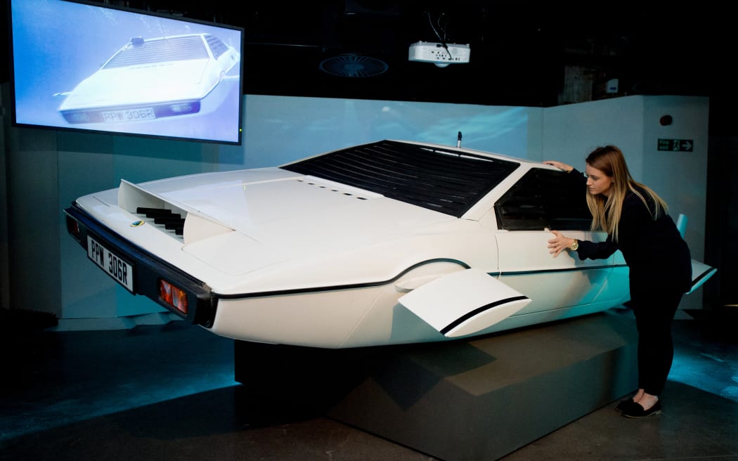 A woman poses with "Wet Nellie" from the James Bond film "The Spy Who Loved Me" at the press preview for the exhibition "Bond in Motion" at the London Film Museum in central London on March 18, 2014.