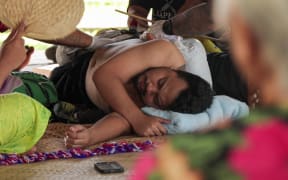Anric's grandmother looks on during a tatau session