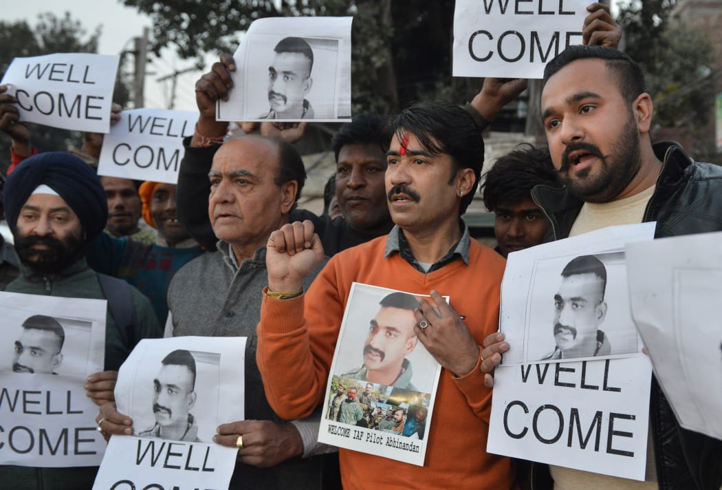 Indian people hold placards and photographs of Indian Air Force pilot Abhinandan Varthaman, as they celebrate the announcement of his soon release, in Amritsar.