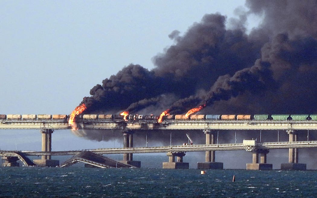 Black smoke billows from a fire on the Kerch bridge that links Crimea to Russia, after a truck exploded, near Kerch, on October 8, 2022. - Moscow announced on October 8, 2022 that a truck exploded igniting a huge fire and damaging the key Kerch bridge -- built as Russia's sole land link with annexed Crimea -- and vowed to find the perpetrators, without immediately blaming Ukraine. (Photo by AFP)