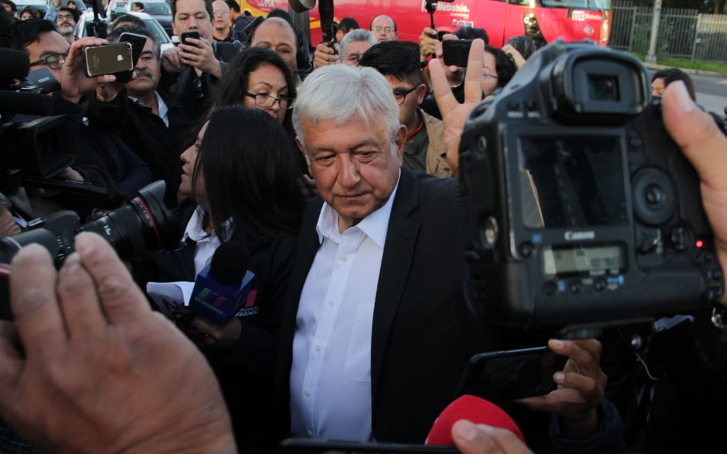 01 July 2018, Mexico, Mexiko City: Politician Andres Manuel Lopez Obrador (C), presidential candidate for the party Morena, speaking to journalists after casting his vote in the election.