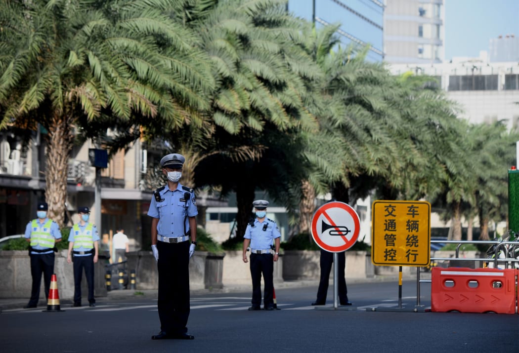 Policemen stand guard on a road leading to the US Consulate in Chengdu.