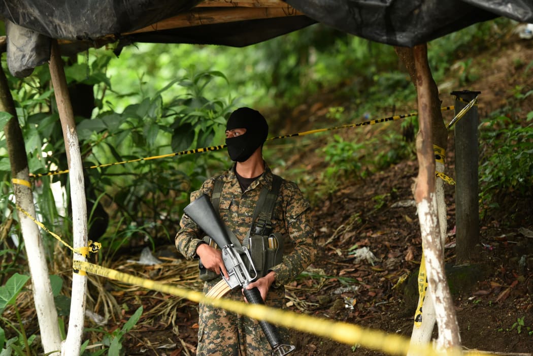 A soldier stands guard at a crime scene where three bus drivers and another man were killed by alleged gang members in Mejicanos, a suburb of San Salvador, on 5 October 2015.