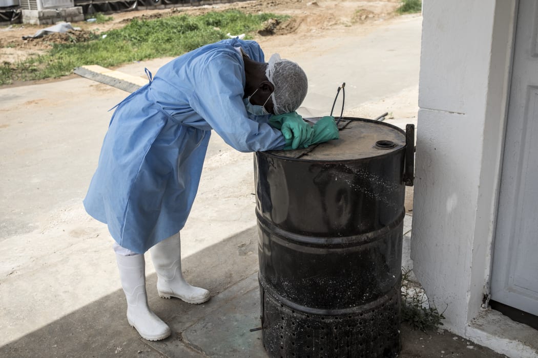 A hygienist rests as he waits outside a decontamination area in a COVID-19 coronavirus treatment centre that cares for positive patients that show little or no symptoms in Dakar.