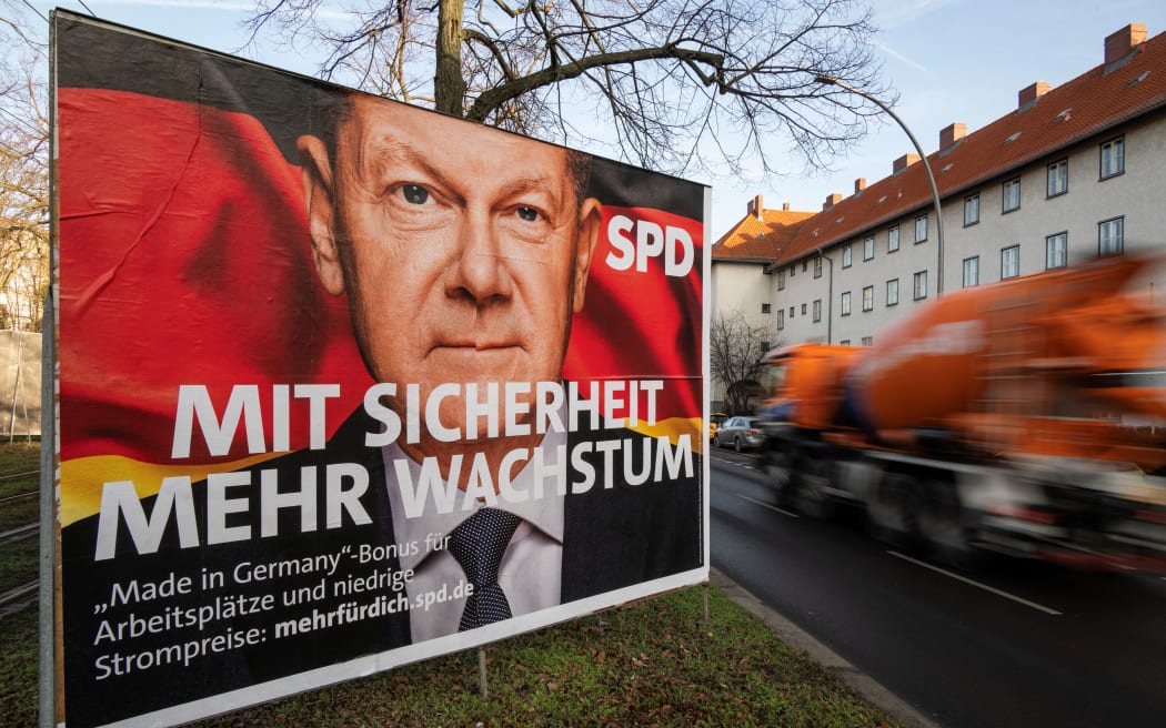 An election campaign poster for the Social Democratic Party (SPD) features a portrait of German Chancellor Olaf Scholz in Berlin on January 20, 2025, ahead of parliamentary elections due to take place in February. Slogan reads: "With security, more growth". (Photo by John MACDOUGALL / AFP)