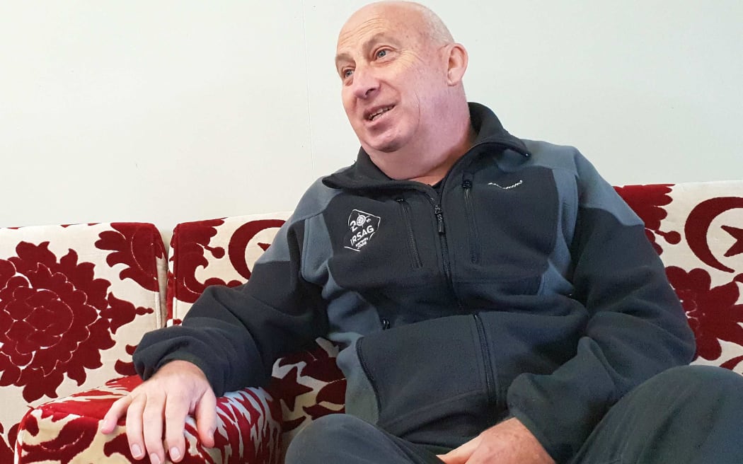 Man sitting on couch with a big red pattern