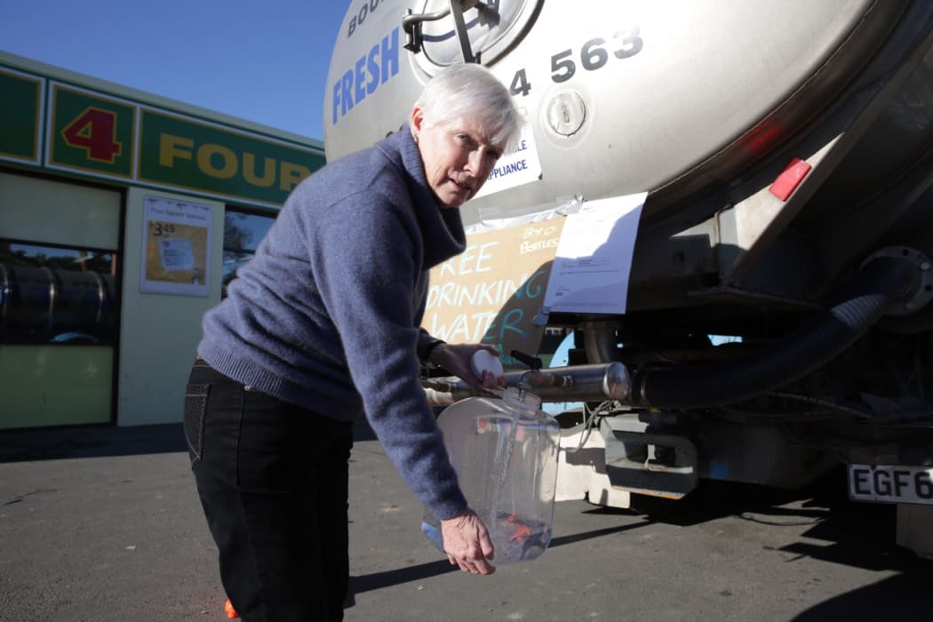 Gail O'Donnell collects drinking water from a tanker.