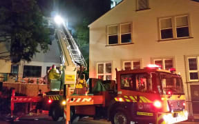 Fire fighters check the ceiling cavities for spread of the fire.