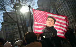 Protesters hold signs outside the Criminal Court where Luigi Mangione, accused killer of US insurance CEO Brian Thompson, attends a hearing in New York City on February 21, 2025. Mangione is accused of gunning down Thompson in a brazen hit in New York on December 4, 2024, pleaded not guilty to state charges including "terrorist" murder. The suspect is charged in both state and federal court. (Photo by ANGELA WEISS / AFP)