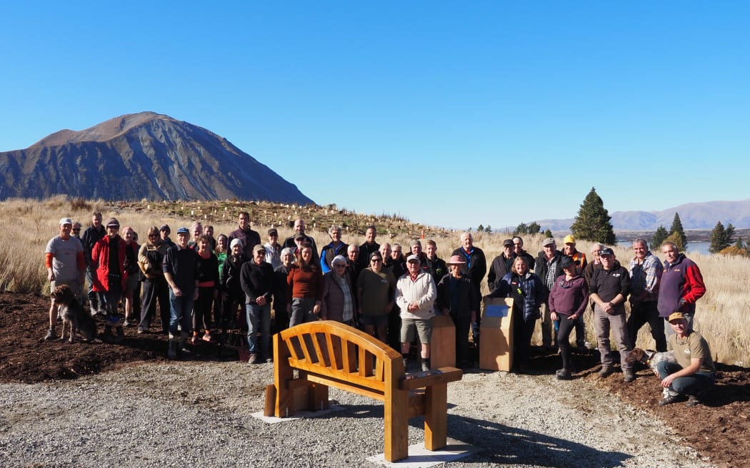 People planting trees near the Lake Ōhau alpine village.