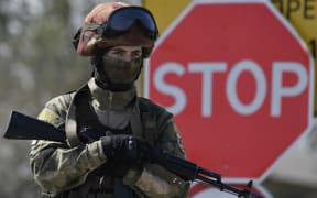 A Russian soldier stands guard at the site of the restoration of the North Crimean Canal in the Kherson region.