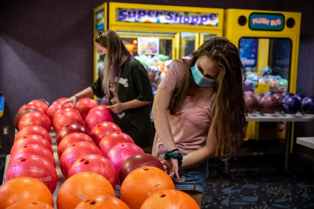 (FILES) In this file photo bowlers pick up clean balls at Westgate Lanes in Austin, Texas on May 22, 2020. - Texas on June 25, 2020 halted steps to reopen its economy after a sharp rise in coronavirus cases