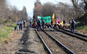 30 Extinction Rebellion members sat on the train tracks in Woolston near Christchurch on Friday, 9 August.