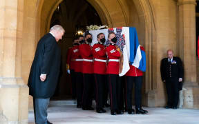 Pallbearers carry the coffin of Britain's Prince Philip, Duke of Edinburgh draped with his Personal Standard to the purpose built Land Rover Defender for the ceremonial funeral procession to St George's Chapel in Windsor Castle in Windsor, west of London, on April 17, 2021.