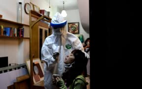 A health worker tests a woman for Covid-19 in her house in Hanoi, Vietnam's capital city.