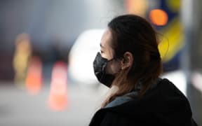 A woman wearing a face mask during the second day of the SkyCity fire.