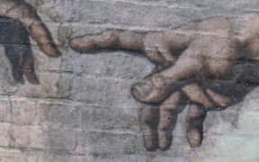 Finger of god painted on a wall in Auckland, a replica of Adam's Creation Sistine Chapel ceiling' by Michelangelo.