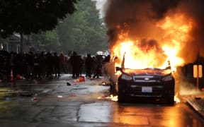 Vehicles burn following demonstrations protesting the death of George Floyd, a black man who died May 25 in the custody of Minneapolis Police, in Seattle, Washington on May 30, 2020.