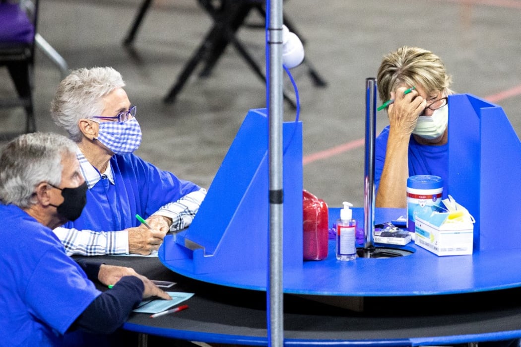 Contractors working for Cyber Ninjas, who was hired by the Arizona State Senate, examine and recount ballots from the 2020 general election at Veterans Memorial Coliseum 1 May, 2021 in Phoenix, Arizona.