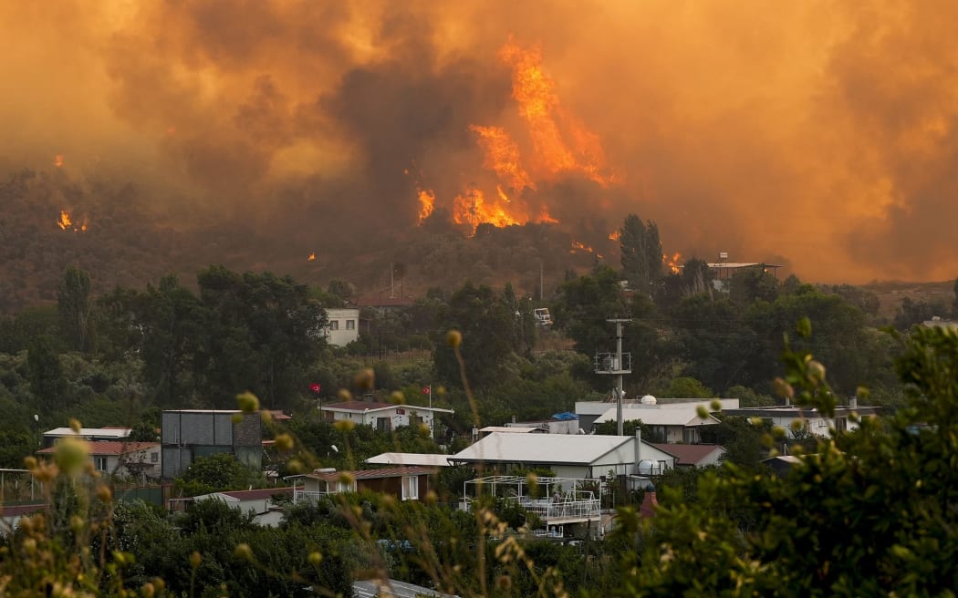 Smoke and flames from wildfires in Seferihisar district of Izmir, Turkiye on June 30, 2025.