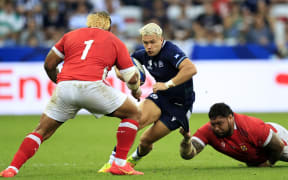 Scotland's wing Darcy Graham (C) is tackled by Tonga's tighthead prop Ben Tameifuna (R)  during the France 2023 Rugby World Cup Pool B match between Scotland and Tonga at Stade de Nice in Nice, southern France on September 24, 2023. (Photo by Valery HACHE / AFP)