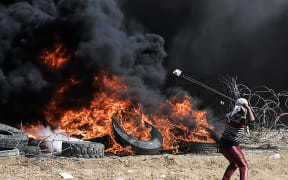 A Palestinian protestor uses a slingshot