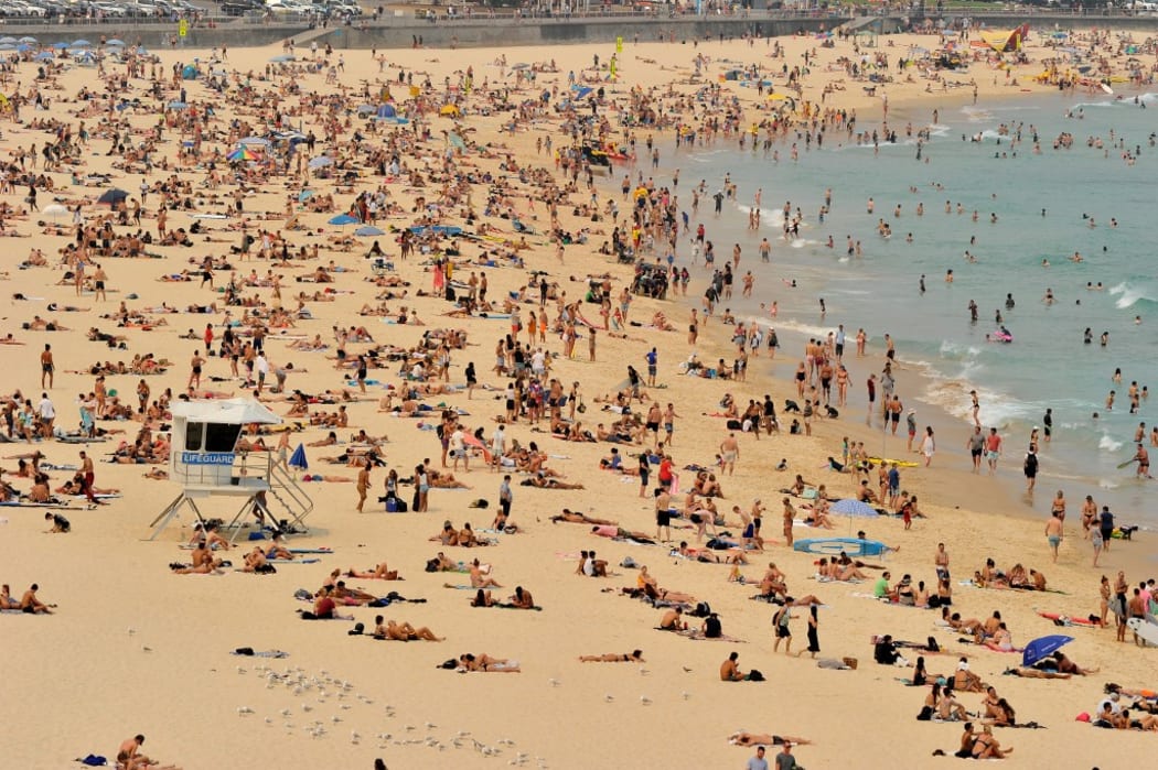 Sunbathers are seen on Bondi Beach as temperatures soar in Sydney on December 21, 2019. - Australia this week experienced its hottest day on record and the heatwave is expected to worsen, exacerbating an already unprecedented bushfire season, authorities said. (Photo by FAROOQ KHAN / AFP)