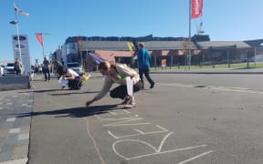 Jamie Stevenson helps draw an Extinction Rebellion mural connecting the Christchurch City Council and regional council offices.
