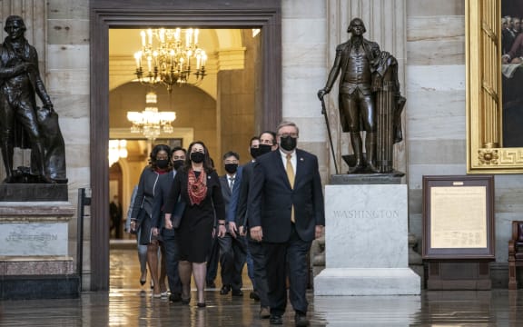 House impeachment managers proceed through the Capitol Rotunda from the House side of the US Capitol to the US Senate chamber.