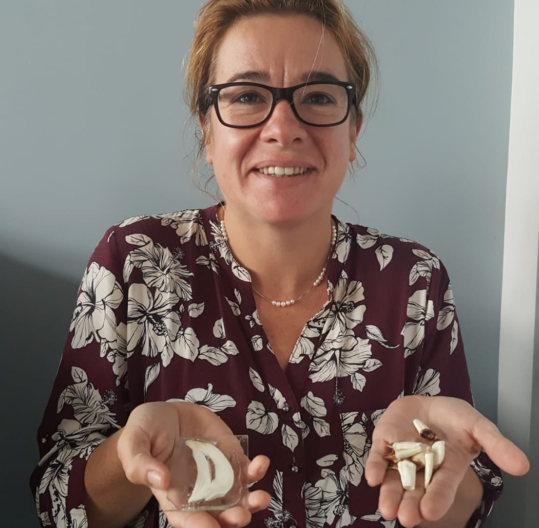 Brittany Graham holding samples of teeth that she has analysed to find out where marine animals travel and feed.