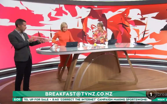 Breakfast host Chris Chang lines up a shot on a Trump doll in January 2023.