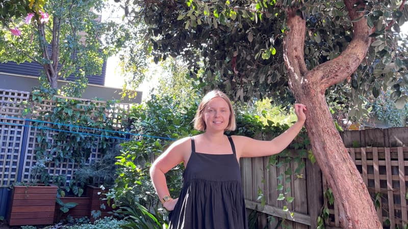 Piera Maclean leaning on a feijoa tree.