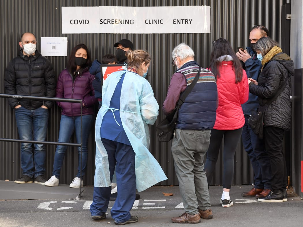 A medical worker speaks to people queueing for coronavirus testing at The Royal Melbourne Hospital on 16 July.