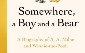 A small boy holds onto a blue balloon and looks down at his yellow toy bear at his feet