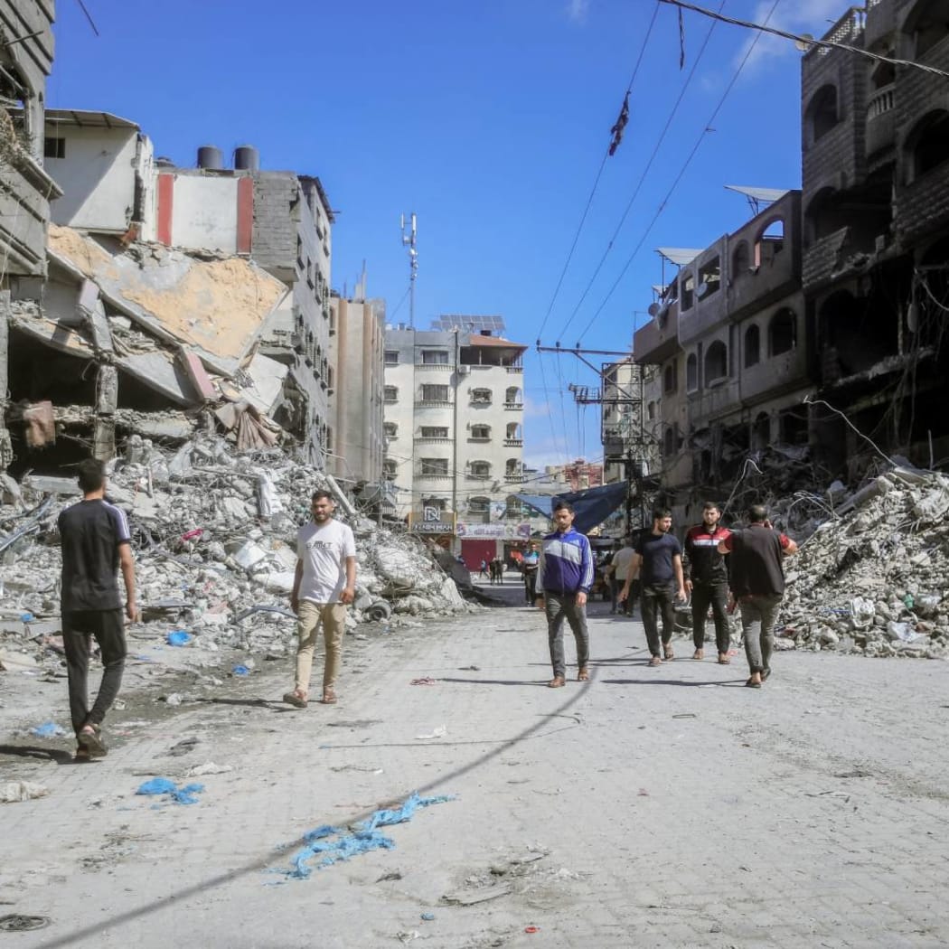 10/15/2023 Gaza, Palestine. People walking amidst the destruction of houses and streets in Khan Yunis, located in the southern Gaza Strip, amid the devastation caused by Israeli airstrikes. (Photo by Mohamed Zaanoun / Middle East Images / Middle East Images via AFP)
