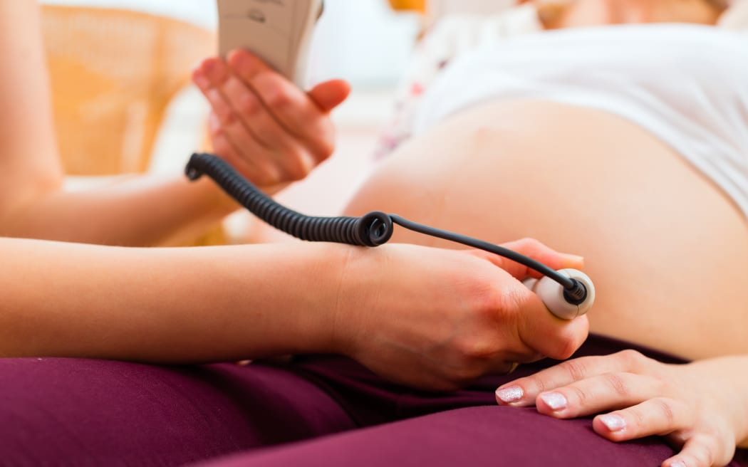 A file photo shows a midwife with a pregnant woman.