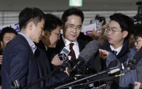 Samsung Electronics vice chairman Lee Jae-yong, centre, arrives to be questioned as a suspect in the  corruption scandal that led to the impeachment of President Park Geun-Hye, at the office of the independent counsel in Seoul, on 12 January, 2017.