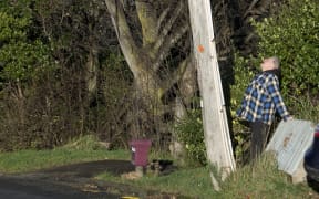 Jeff Gladden looks up at leaning power pole
