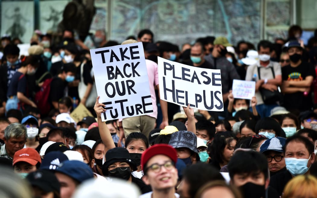Anti-government protesters hold up signs during a rally at Democracy Monument in Bangkok on 16 August 2020.
