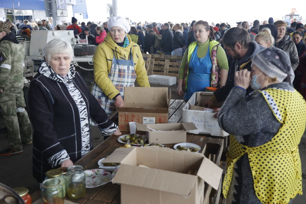 Mariupol residents seeking food and drink on Friday. A humanitarian aid centre continues to operate in Mariupol, where the Russian Army has taken control.