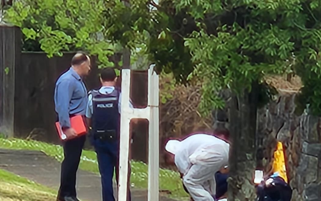Police officers, some in white forensic suits, collecting samples from the area.