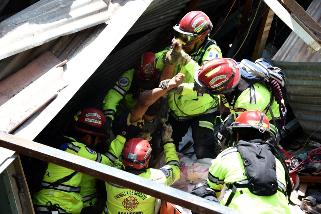 Rony Pu is rescued alive after a landslide at Cambray village