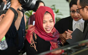 Indonesian national Siti Aisyah (C) smiles while leaving the Shah Alam High Court, outside Kuala Lumpur on March 11, 2019 after her trial for her alleged role in the assassination of Kim Jong-nam.