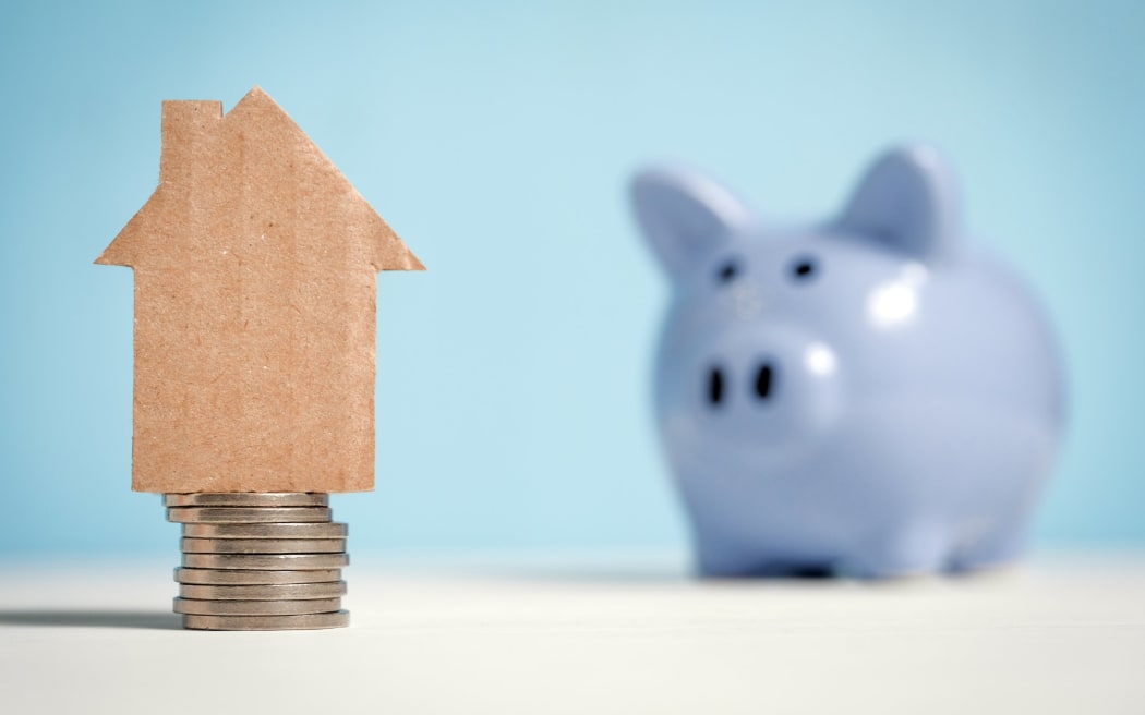 Illustration of savings with coins, a piggy bank and a model of a house.