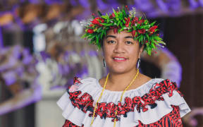 Cora-Allan is a smiling woman in traditional Niuean clothing and headwear.