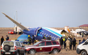 Emergency specialists work at the crash site of an Azerbaijan Airlines passenger jet near the western Kazakh city of Aktau on 25 December. (Photo by Issa Tazhenbayev / AFP)