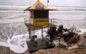 A lifeguard tower is surrounded by water on Main Beach that has been damaged by record-breaking waves caused by the outer fringe of Tropical Cyclone Alfred on the Gold Coast on 7 March.