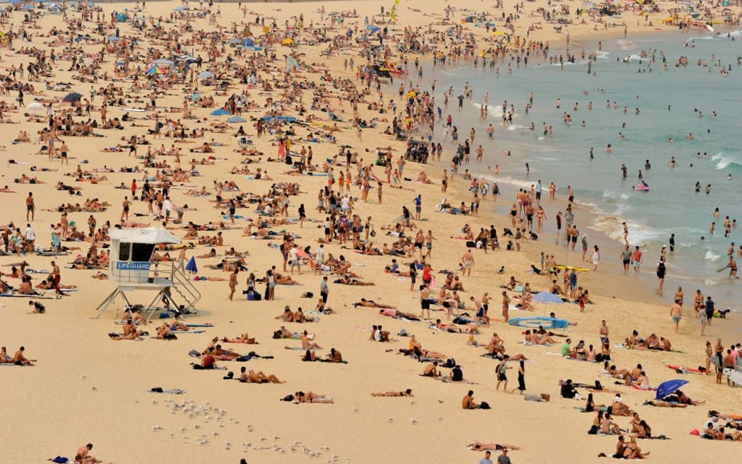 Sunbathers are seen on Bondi Beach as temperatures soar in Sydney on December 21, 2019. - Australia this week experienced its hottest day on record and the heatwave is expected to worsen, exacerbating an already unprecedented bushfire season, authorities said. (Photo by FAROOQ KHAN / AFP)